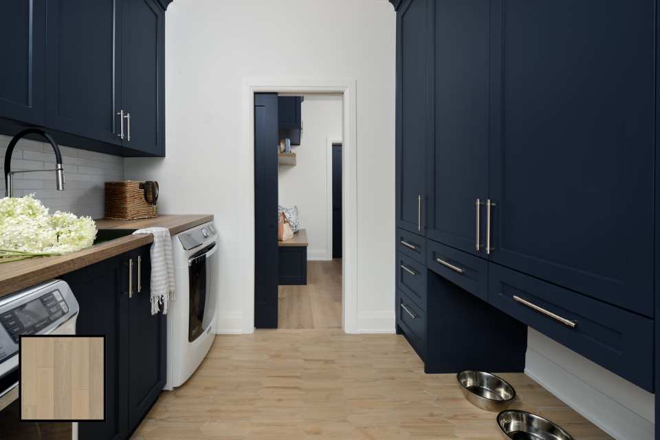 combined laundry mudroom with navy blue cabinets, white oak floors and sliding pocket door